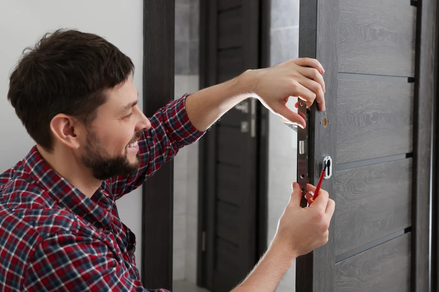 Artisan réglant une fermeture de porte dans un logement de La Garenne-Colombes (92250)
